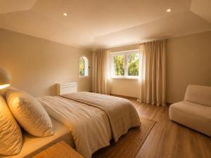 a bedroom with a bed and a chair and a window at Quinta do Carril in Reguengo +117 photos