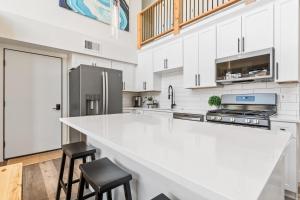 a white kitchen with a large white counter and stools at Quarry B8 in Whitefish
