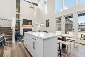 a kitchen with white cabinets and a table and a fireplace at Quarry B8 in Whitefish +38 photos