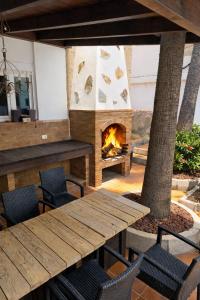 a wooden table and chairs and a fireplace at Zaks House Valle San Lorenzo in Arona