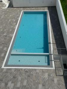 a large swimming pool with blue water at Apartamento B T4 Pombal in Pombal