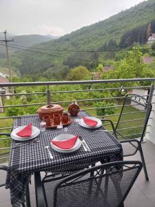 a table with plates and utensils on a balcony at Apartmani Vlatkovic 1 Zavojsko jezero in Pirot +6 photos