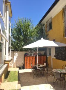 een patio met een parasol en tafels en stoelen bij Tribu Malen Apartamentos in Temuco