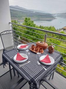 a table with red and white plates on a balcony at Apartmani Vlatkovic 1 Zavojsko jezero in Pirot