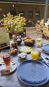 a table with plates of food and drinks on it at Hotel Pension de Tipmast in Bladel