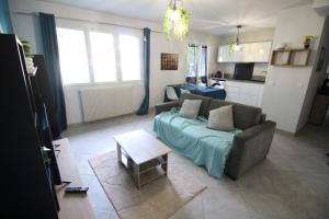 a living room with a couch and a table at T2 moderne, Parking, Proche Valence & Autoroute in Bourg-lès-Valence