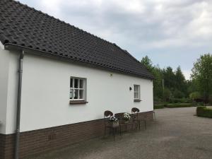 a white building with two chairs and a table at For a wonderful outdoor feeling! in Zelhem