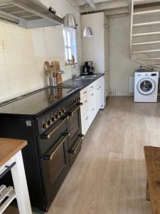 a kitchen with a black stove and a sink at For a wonderful outdoor feeling! in Zelhem