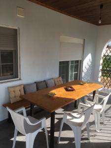 a wooden table and some white chairs and a couch at Villa Archontiko in Mirodháton