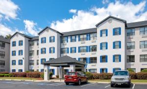 a large white building with cars parked in a parking lot at InTown Suites Extended Stay Marietta GA - Town Center in Kennesaw