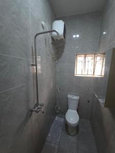 a bathroom with a toilet and a shower with a window at House 27 Crown in Idu