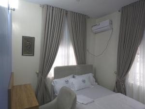 a bedroom with a white bed and a window at House 27 Crown in Idu