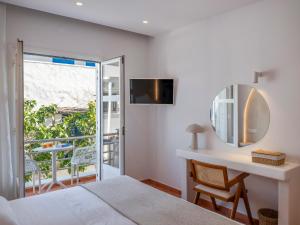 a bedroom with a bed and a desk with a mirror at Galini Rooms in Naousa