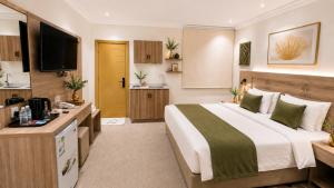 a hotel room with a bed and a television at أمكو للشقق المخدومة in Jeddah
