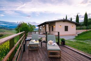 a deck with two chairs and a house at PinetoAlba Country House in Scerne