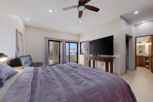 a bedroom with a bed and a flat screen tv at Casa Girasol Ocean Views Steps to Beach in Buenavista