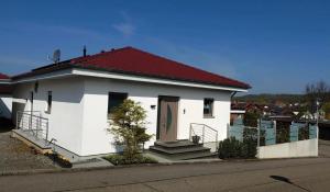 a small white house with a red roof at Gästezimmer La Siesta in Ötisheim
