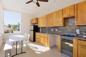 a kitchen with wooden cabinets and a table and a counter top at Casa Girasol Ocean Views Steps to Beach in Buenavista