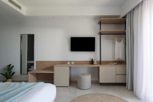 a bedroom with a desk and a tv on a wall at Suite Home in Anthoúsa