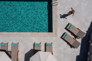 an overhead view of a pool with chairs and a man swimming at Suite Home in Anthoúsa
