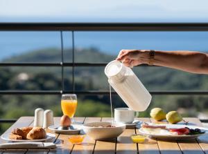 a person pouring milk into a table of food at Suite Home in Anthoúsa