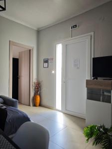 a living room with a sliding door and a television at Elina House and Garden in Nikiti