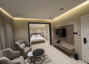 a hotel room with a bed and a television at Bluestone Amlak 1 in Medina