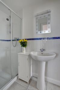 a white bathroom with a sink and a shower at 2 Bed in Woolacombe oc-shore1 in Woolacombe