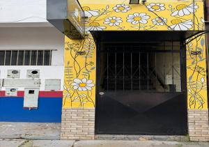 a building with a black door with flowers painted on it at Margarida AP 2 in Presidente Figueiredo +6 photos