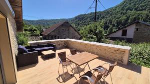 a patio with a table and chairs on a balcony at La cabane du pédaleur in Fourbanne