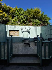 a fence with tables and benches in front at Old Mill Cottage in Swinford +22 photos