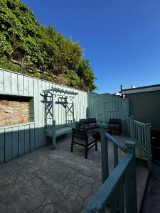 a patio with two benches and a fence at Old Mill Cottage in Swinford