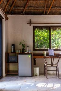 a kitchen with a table and a refrigerator at Yayum Bacalar in Bacalar