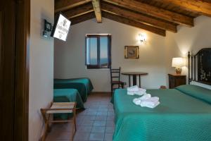 a hotel room with two green beds and a table at Il Castello di San Sergio in Centola