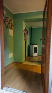 an empty living room with green walls and a microwave at Casa Bella Vista in La Spezia