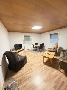 a living room with couches and a tv and a table at Private Apartment centrally located in Grafenwöhr