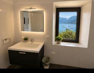 a bathroom with a sink and a window with a view at Diamante sull'acqua in Sale Marasino