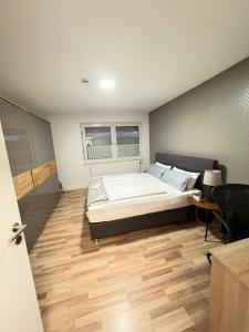 a bedroom with a large bed and a wooden floor at Private Apartment centrally located in Grafenwöhr