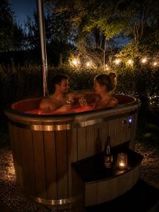 a man and woman sitting in a hot tub at night at Bed&Bus met dakterras in Rucphen +1 photo