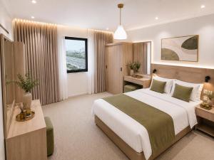 a bedroom with a large white bed and a window at أمكو للشقق المخدومة in Jeddah