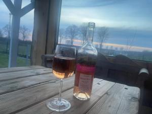 a glass of wine sitting next to a bottle of wine at Chatka u Radka in Radacz