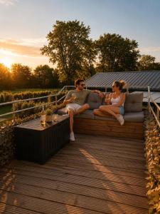 a man and woman sitting on a couch on a deck at Bed&Bus met dakterras in Rucphen
