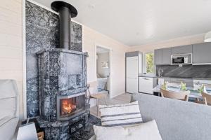 a living room with a fireplace and a kitchen at Villa Rantakukka Koli, oma ranta in Kolinkylä
