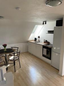 a small kitchen with a table and a refrigerator at The White Farm in Skanderborg