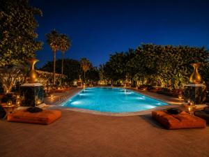 a swimming pool at night with vases around it at BLACK AMBER BOUTIQUE HOTEL in Lampi