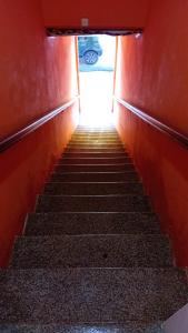 a stairway leading up to a red wall with stairs at Pousada Jardim Alameda in Blumenau +6 photos