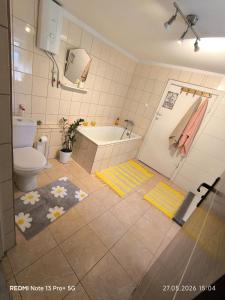 a bathroom with a tub and a toilet and a sink at Sielskie Markowskie in Markowskie +42 photos
