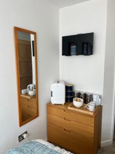 a bedroom with a dresser with a microwave and a mirror at Olive Mae - Cosy Room with private en-suite bathroom in Blackwood