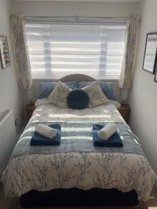 a bedroom with a bed with two pillows and a window at Olive Mae - Cosy Room with private en-suite bathroom in Blackwood