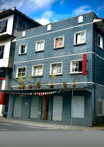 a blue building with a red sign on it at Pousada Jardim Alameda in Blumenau